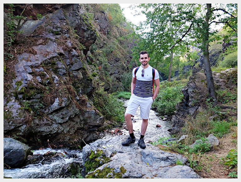 half day in the rocks - standing man beside waterfall